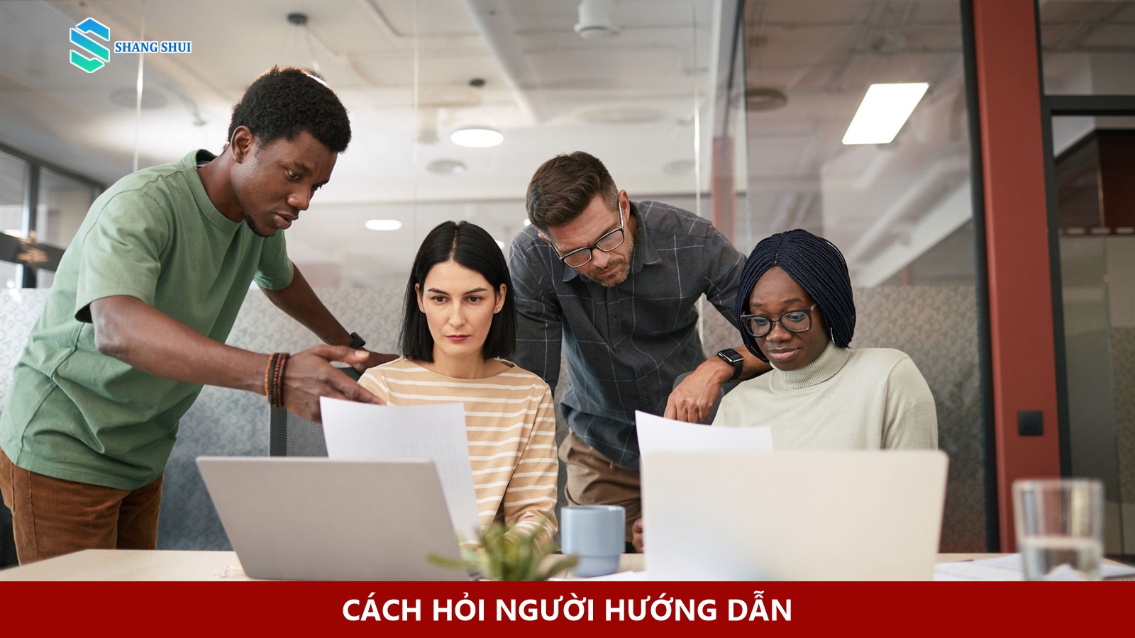 Nhân viên trẻ trao đổi câu hỏi cụ thể cùng người quản lý trong phòng làm việc.