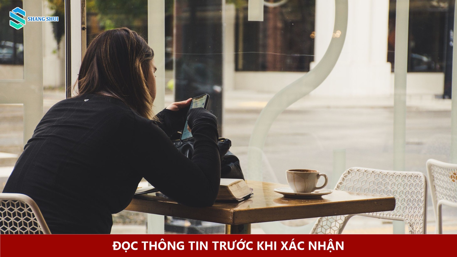 Người ngồi ở quán cà phê xem màn hình điện thoại cạnh tách cà phê