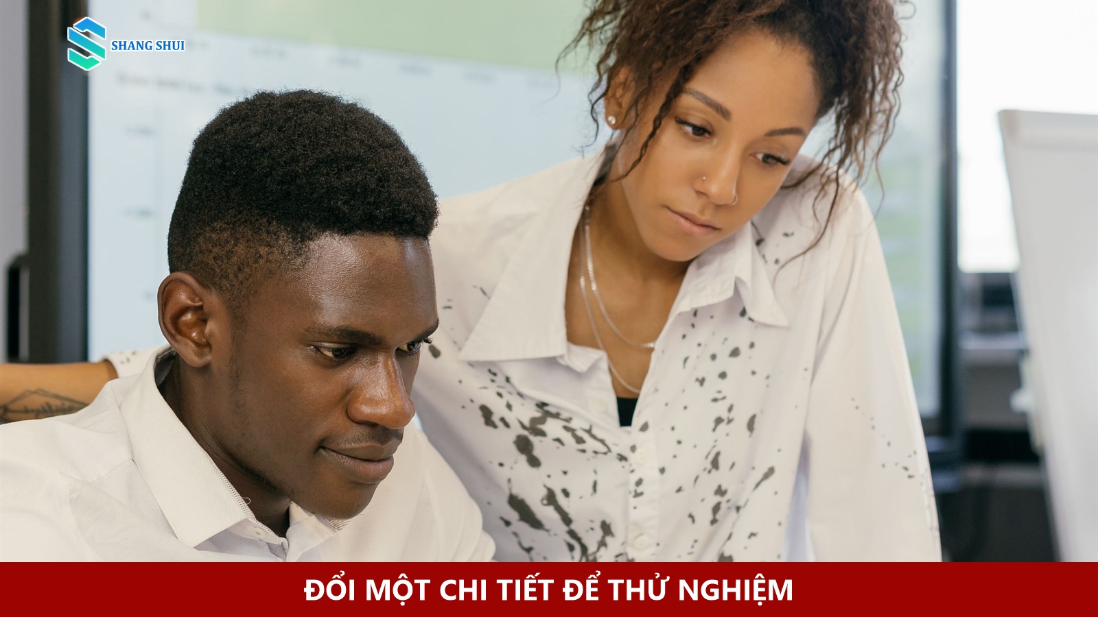 Hai nhân viên cùng kiểm tra số liệu nhấp chuột trên máy tính xách tay.