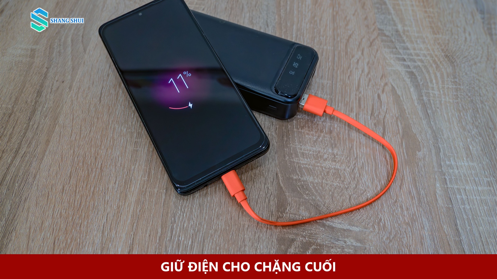 Điện thoại nối với pin dự phòng bằng cáp màu cam.