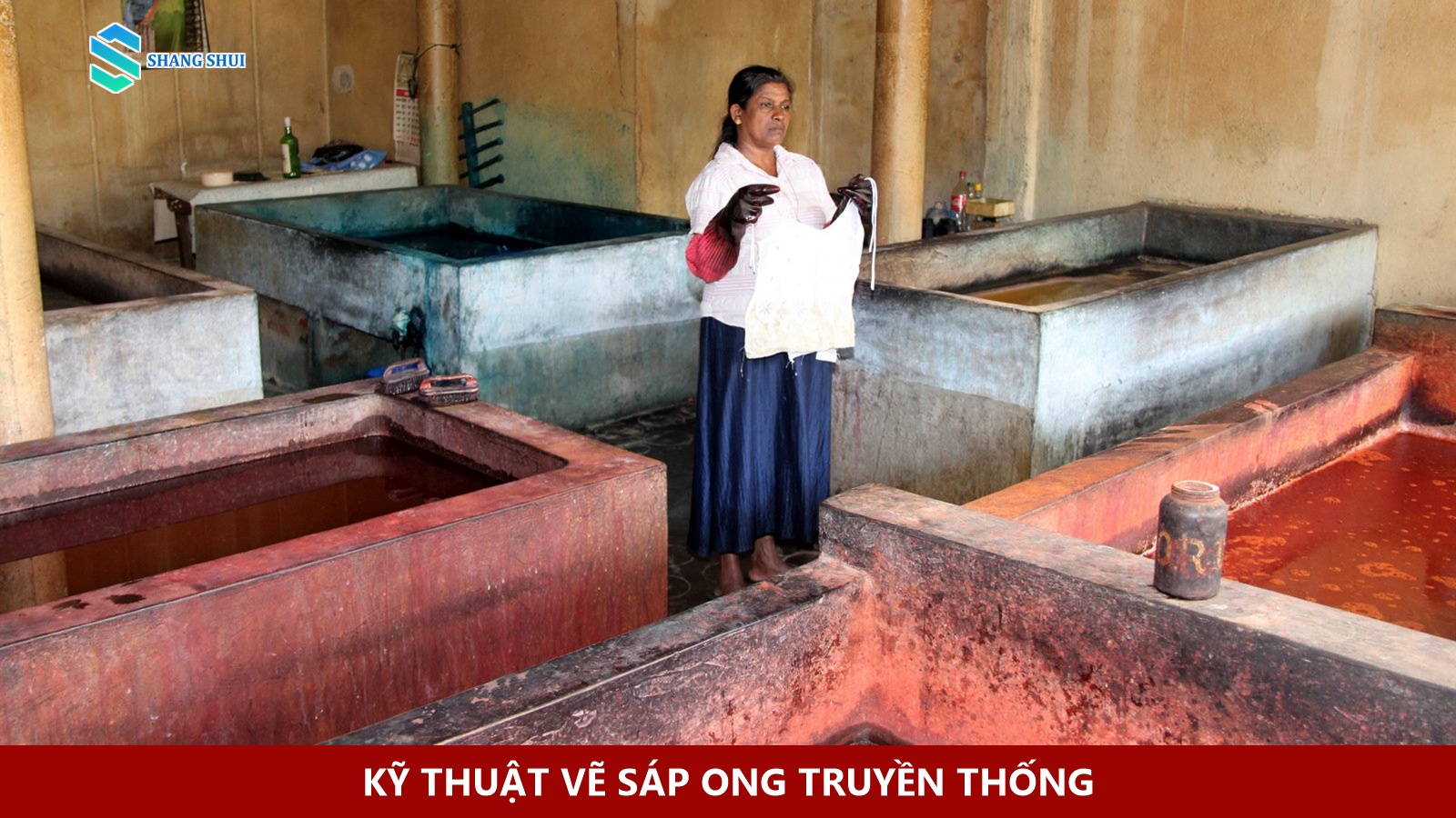 Nghệ nhân dùng bút vẽ sáp nóng trên vải batik tại xưởng Sri Lanka.