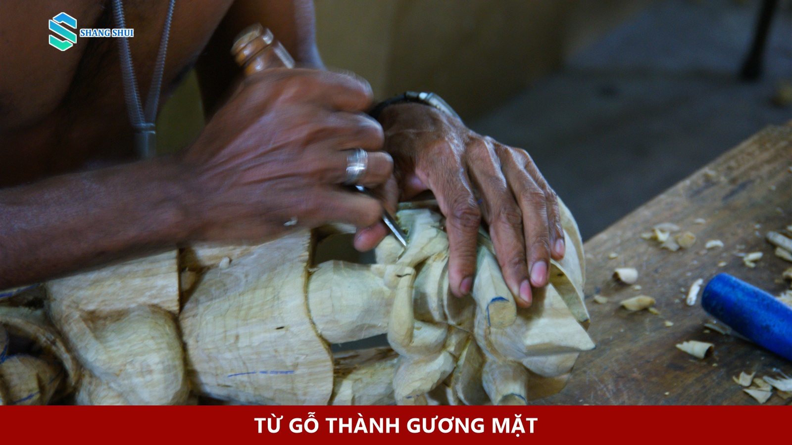 Thợ thủ công dùng dụng cụ tay để chạm một mặt nạ gỗ chưa sơn.
