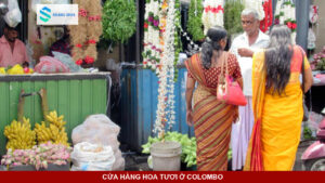 Sạp hoa tươi rực rỡ sắc màu bên cạnh ngôi đền Hindu tại Colombo.